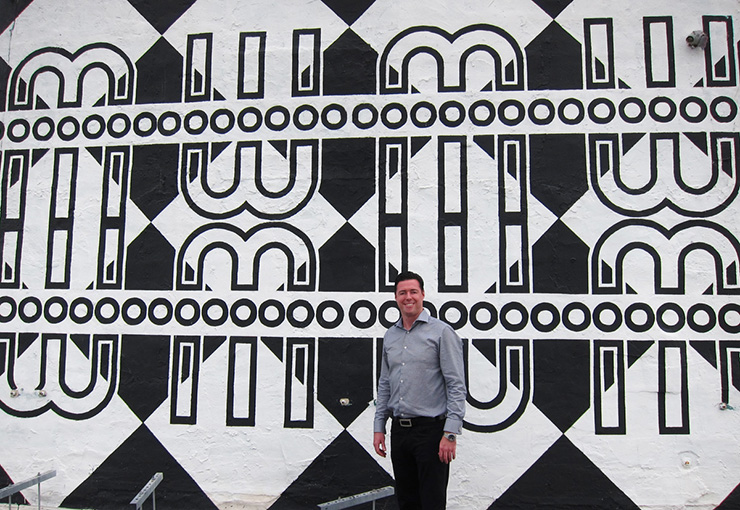 Sean McCormick with Eleazar Delgado's 111 3rd St roof mural.