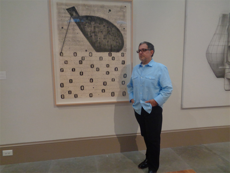 Artist Mario Bencomo stands in front of his large-scale illustration during the Opening Night Reception.