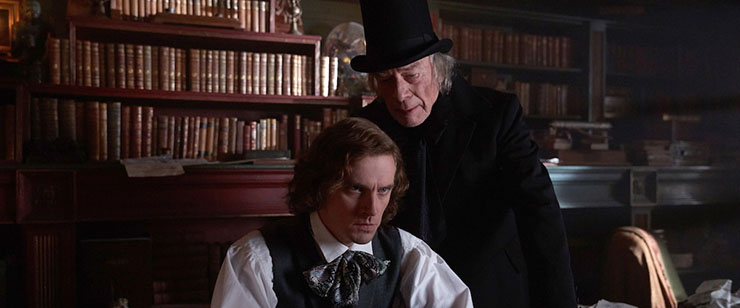 Dan Stevens as Charles Dickens and Christopher Plummer as Scrooge in 