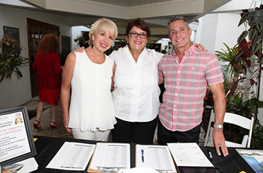 Cameron Basden, Vivian San Juan and Jimmy Thomas check people in at the 10th anniversary party at Miami Beach Botanical Garden.