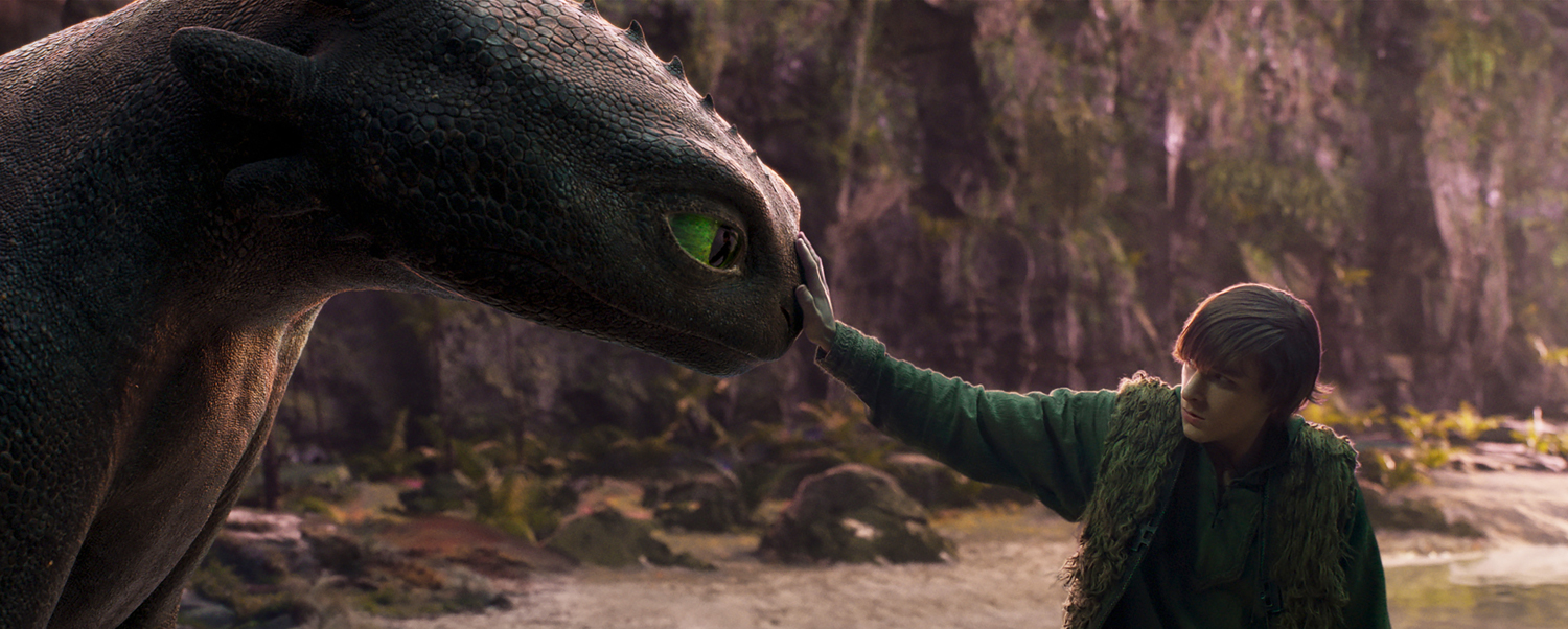 Mason Thames as Hiccup with his Night Fury dragon, Toothless, in a scene from