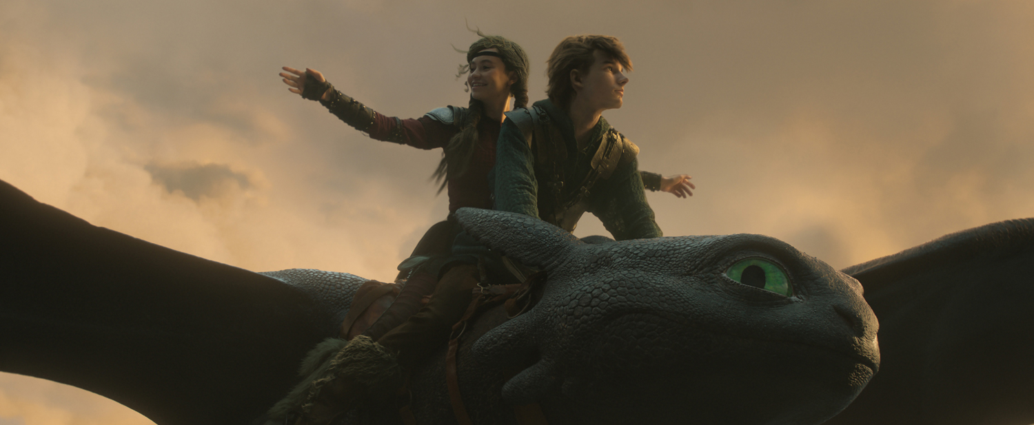 Nico Parker as Astrid, Mason Thames as Hiccup and Night Fury dragon, Toothless, in a scene from