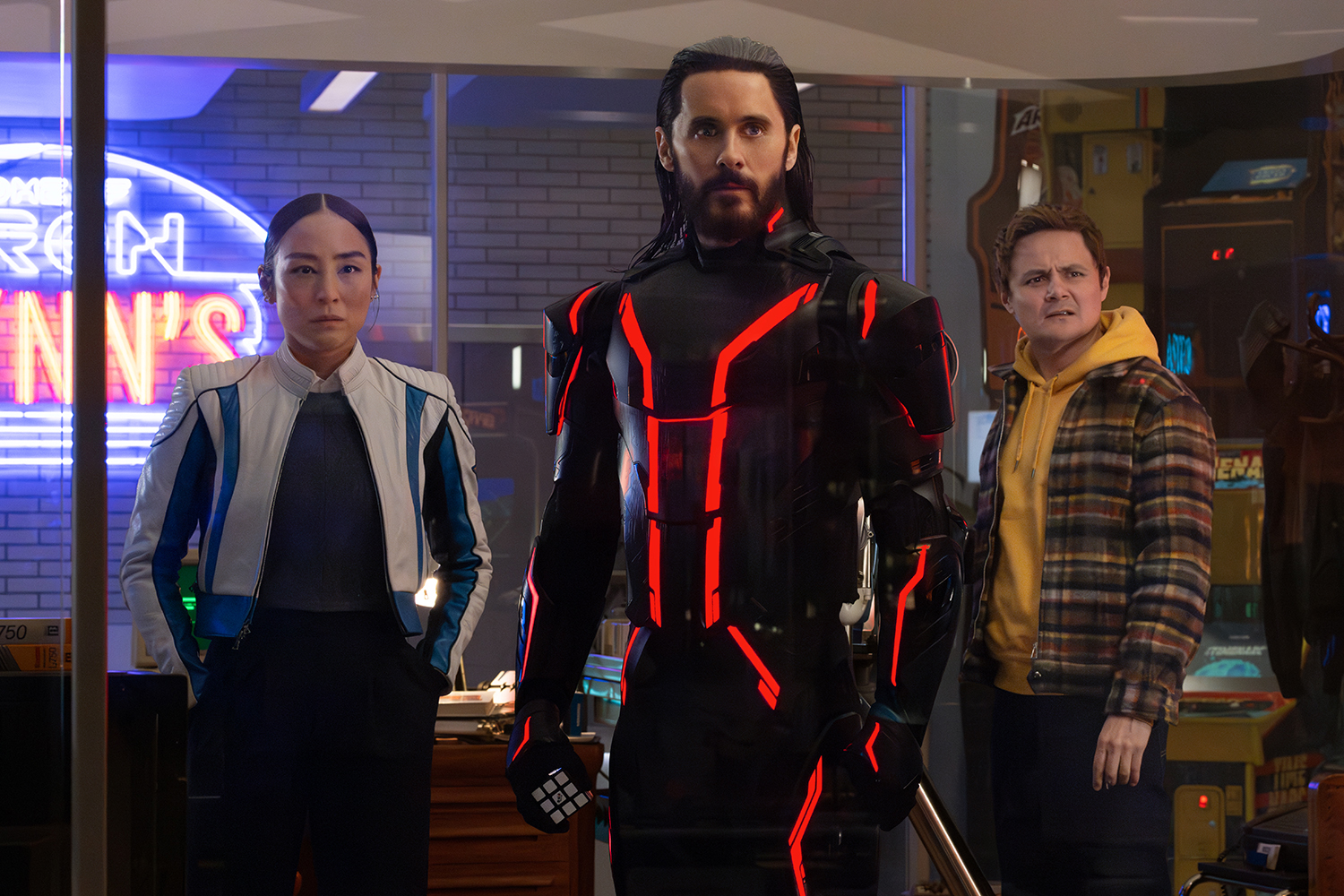 Greta Lee as Eve Kim, Jared Leto as Ares, and Arturo Castro as Seth Flores in a scene from 