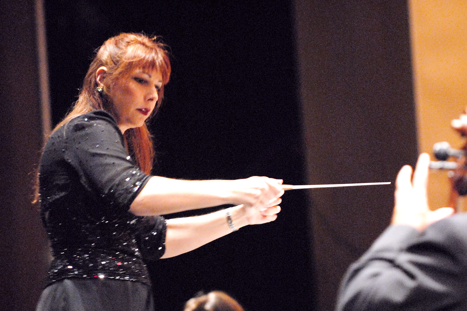 Orchestra Miami Artistic Director and Conductor Elaine Rinaldi pointing the baton (Photo courtesy of Orchestra Miami)