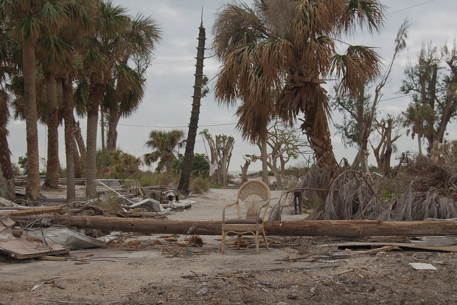 A chair, a downed telephone and debris along the shoreline after a hurricane in the documentary 