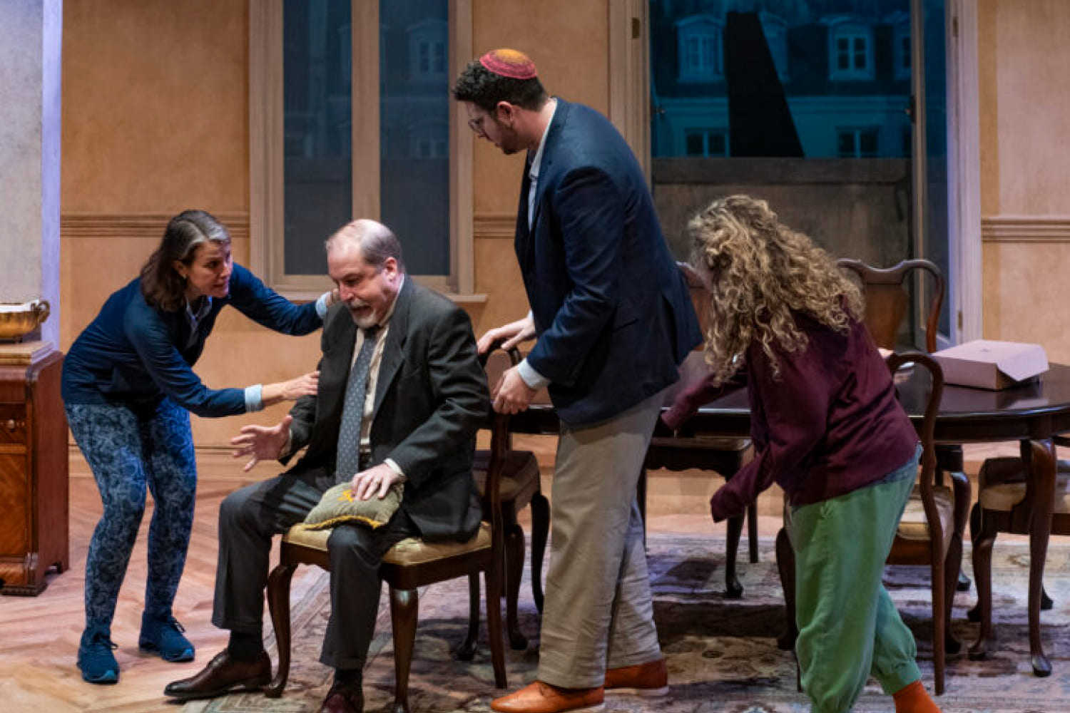 Family members gather around Charles Benhamou (Stephen Trovillion) as he feels panicky. From left is Marcelle Salomon Benhamou (Elizabeth Price), Daniel Benhamou (Jeremy Sevelovitz), and Elodie Benhamou (Irina Kaplan). (Photo by Magnus Stark)