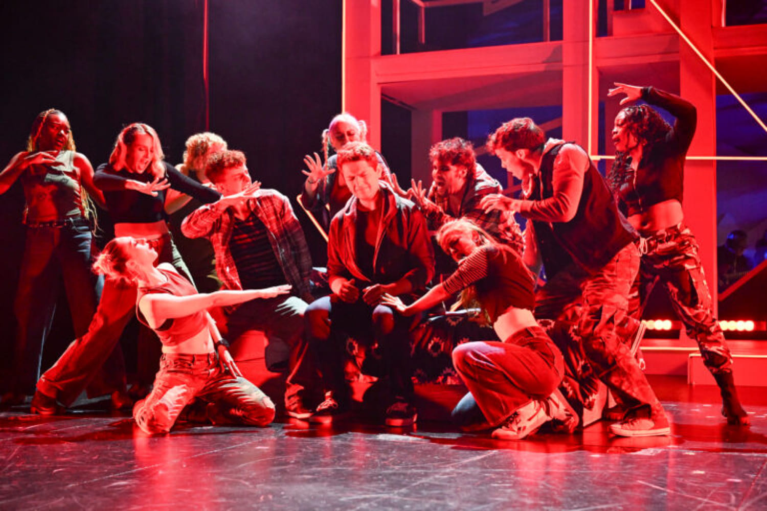 Red lighting rains down during a passionate moment from the production. (Photo by Larry Marano)