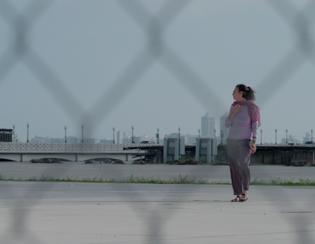 Maggie Steber, former assistant managing editor of photography and features at the Miami Herald, walks through the site where One Herald Plaza once stood during filming of the documentary “News Without a Newsroom.” (Photo courtesy of Oana Martisca)