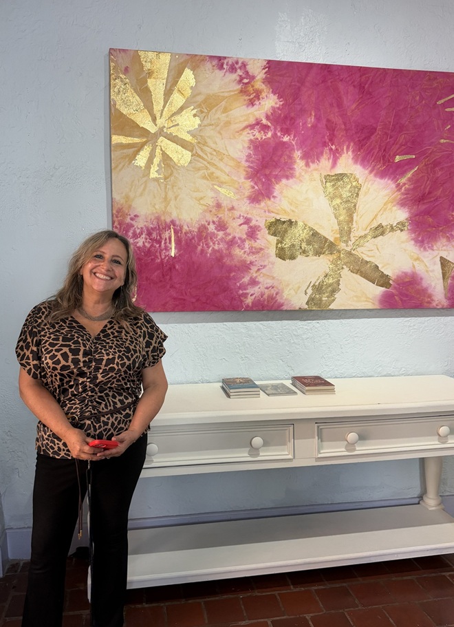 Curator Adrianna Herrera of Aluna Art Foundation at the Tower Hotel. One of Mette Tommerup's paintings is behind her.