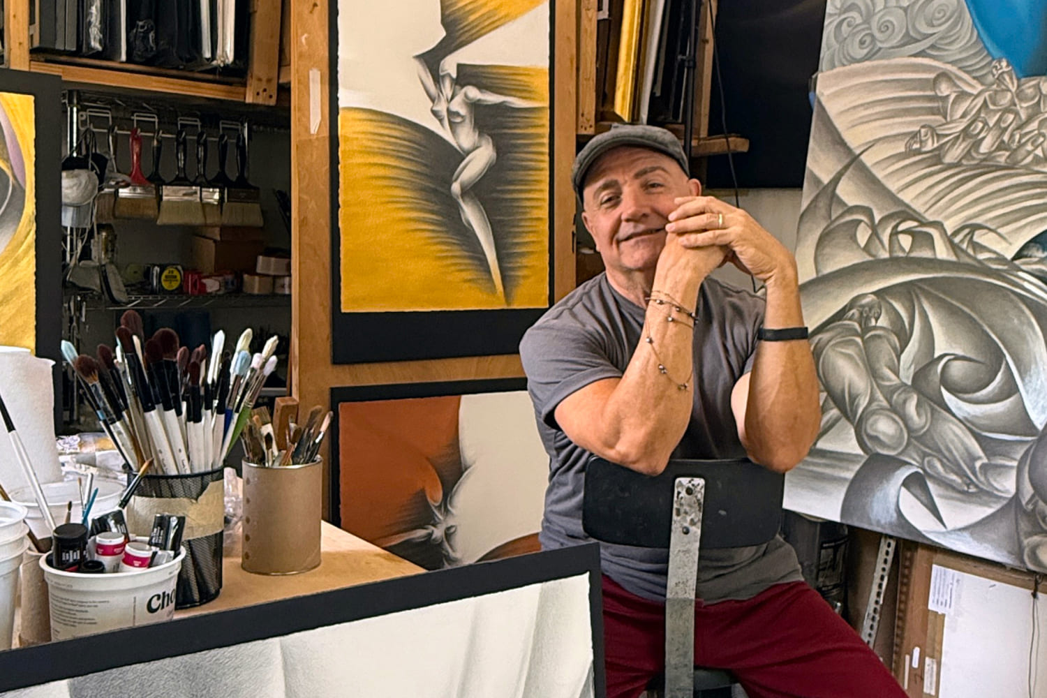 Artist Noel Suarez, pictured with his paintings and brushes, brings his background in ballet and classical art to his role as artist-in-residence at the Miami Design Preservation League's Art Deco Museum. (Photo courtesy of the artist)