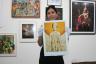 Artist Manuela Lara, holding her artwork