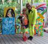 Mark Nedlin and Charlotte Libov, standing with Talia Zoref's paintings